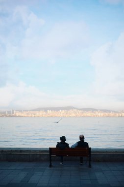 İstanbul 'da deniz kıyısındaki bankta oturan erkeklerin güzel manzarası