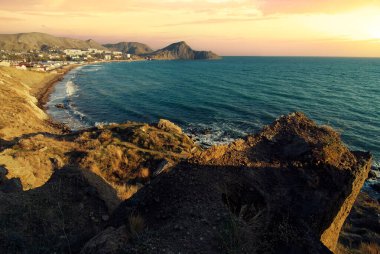 Kaya kıyısı ve mavi gölde gün batımı deniz manzarası