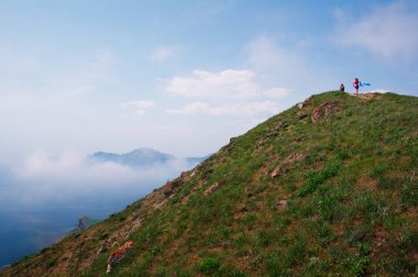 Yürüyüş ve yürüyüş. Deniz koyundaki yeşil tepeler.