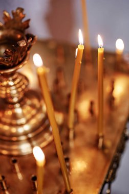 Tapınakta yaldızlı bir şamdanla kilise mumlarını yakmak..