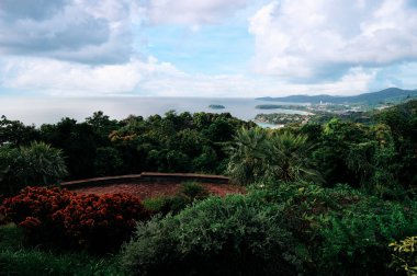 Kata ve Karon plaj manzaralı. Okyanus kıyıları, yeşil tepeler, bulutlu gökyüzü olan güzel bir manzara. Phuket, Tayland.