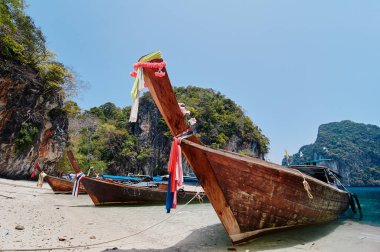 Geleneksel uzun kuyruklu tekneler, kayalar, uçurumlar, tropikal plajlar olan güzel bir manzara. Yengeç, Tayland.