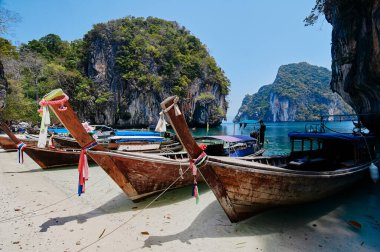 Geleneksel uzun kuyruklu tekneler, kayalar, uçurumlar, tropikal plajlar olan güzel bir manzara. Yengeç, Tayland.