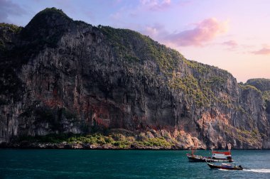 Adada tatil. Deniz, tekne ve kayalarla dolu güzel bir manzara..