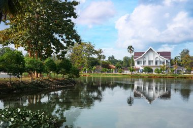 Göl kıyısında güzel bir kır evi olan yaz manzarası.