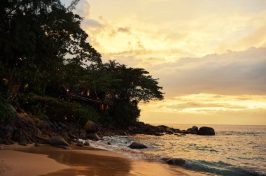 Okyanus sahilinde güzel bir gün batımı. Gökyüzü suya yansıyor.