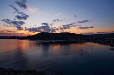 Deniz kıyısında gün batımının olduğu güzel bir manzara..