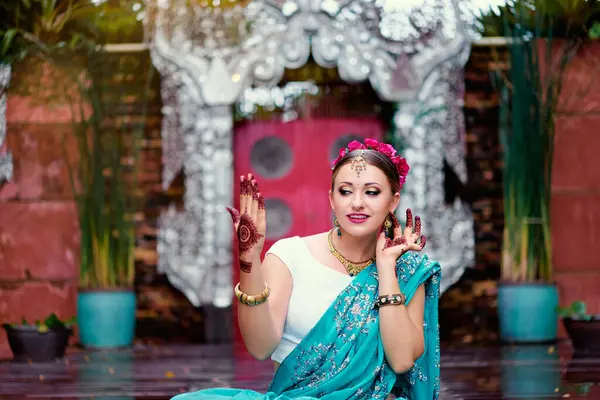 ブライダルのメイクやお寺の庭で踊る手にジュエリーとヘナのタトゥーと伝統的なインド服サリーの若い白人美女 — ストック写真