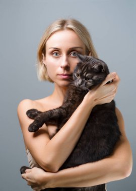 Genç şişkin kadının stüdyo portresi ve onun sevimli siyah tekir kedisi.