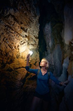 Dağda kazılmış mağarayı keşfeden genç bir kadın..