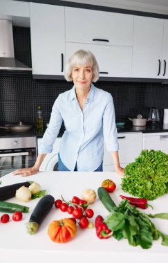Helthy diyeti. Mutfakta sebze hazırlayan mutlu yaşlı kadın..
