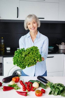 Helthy diyeti. Mutfakta sebze hazırlayan mutlu yaşlı kadın..