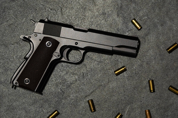 Big black gun pistol on grey background.