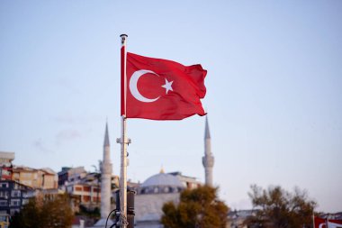 Mavi gökyüzünde ulusal Türk bayrağı dalgalanıyor.