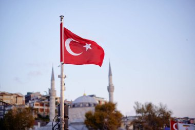 Mavi gökyüzünde ulusal Türk bayrağı dalgalanıyor.
