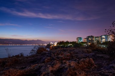 Deniz kıyısında şehir olan güzel bir gece manzarası. Antalya, Türkiye.