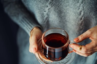 Rahat bir ev. Bir fincan sıcak çay tutan kadın elleri..