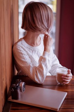 Kapuçino içen bir kadınla blog yazarının çalışma yeri..