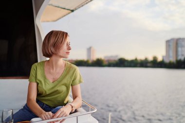 Yatta lüks bir tatil. Tekne güvertesinde Dnipro nehrine yelken açan genç mutlu kadın..