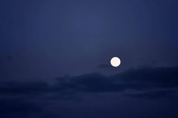 Big full moon on blue night sky.