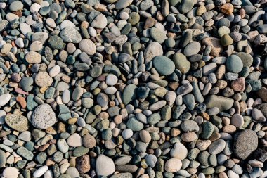 Küçük yuvarlak taşlar arka plan. Taş dokusu. Küçük çakıl taşının pürüzlü yüzeyi.