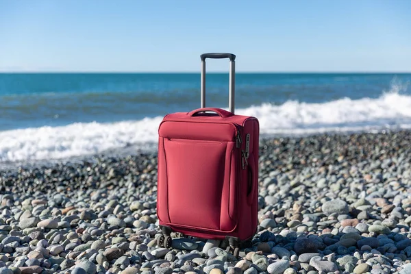 Color Travel Suitcase Pebble Beach Turquoise Sea Background Summer Holidays Стоковое Изображение