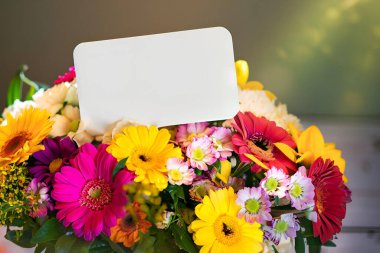 Kağıt etiketli renkli buket, bulanık arkaplan ve sol tarafta büyük bedava fotokopi alanı, parlak ışık, Anneler Günü