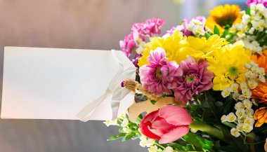 Kağıt etiketli renkli buket, bulanık arkaplan ve sol tarafta büyük bedava fotokopi alanı, parlak ışık, Anneler Günü