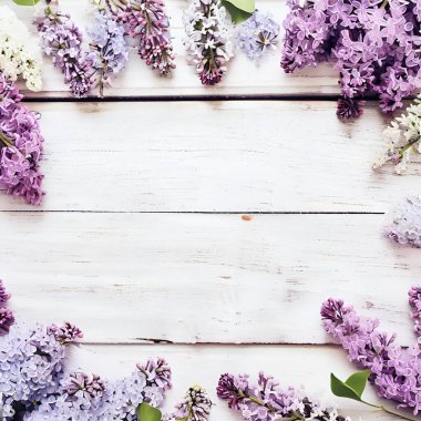 Romantik çiçek kompozisyonu, kırsal beyaz ahşap bir zemin üzerinde gevşek sıralanmış leylak çiçekleri ve ortasında Anneler Günü, Sevgililer Günü, Düğün veya Doğum Günü için bedava fotokopi alanı.