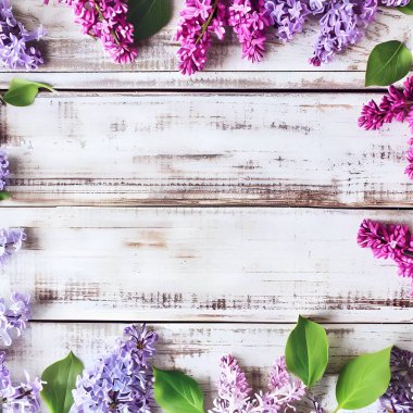 Romantik çiçek kompozisyonu, kırsal beyaz ahşap bir zemin üzerinde gevşek sıralanmış leylak çiçekleri ve ortasında Anneler Günü, Sevgililer Günü, Düğün veya Doğum Günü için bedava fotokopi alanı.