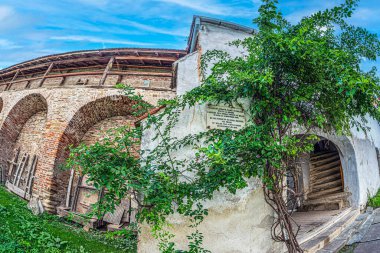 Mosna, Transilvanya, Romanya-Eylül 4, 2021: Tahkim edilmiş evanjelik kilisenin savunma duvarı ve iç avlusu 1490-1520 yılları arasında inşa edildi. Galler Prensi 'nin ziyareti anısına verilen plaket..