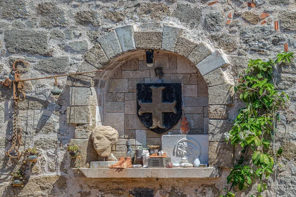 罗得岛罗得岛一座房子的石墙上挂着希腊装饰物 用石头和金属制成 上面印有约安尼人骑士团的标志 — 图库照片