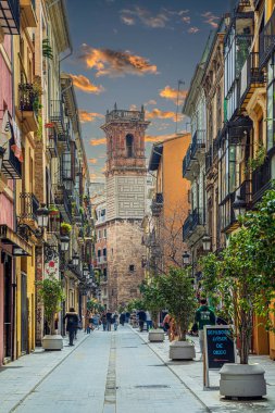 VALENCIA, SPAIN - MARCH 28, 2022: View of Carrer dels Serrans, with Torre de Sant Bartomeu in background. The Tower is the only vestige that remains of the church of the same name, built in 1239.