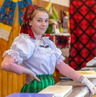 TIMISOARA, ROMANIA - APRIL 20, 2019: Young woman dressed in traditional clothing from Maramures area, present at street Easter fair with traditional products.