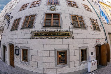 MUNCHEN, GERMANY - 29 Nisan 2023: Denkmal fr Maximilian I. Joseph heykelinin temelinde dinlenen turistler, Max-Joseph-Platz 'da ve Bavyera Devlet Operası önünde.