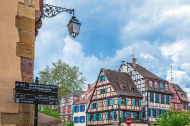 COLMAR, ALSACE, FRANCE - 5 Mayıs 2023: Bu ortaçağ şehrinin tarihi bölgesinde ziyaret etmek için ünlü sitelerin yönünü gösteren sokak işaretleri.