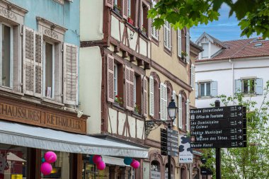 COLMAR, ALSACE, FRANCE - 5 Mayıs 2023: Bu ortaçağ şehrinin tarihi bölgesinde ziyaret etmek için ünlü sitelerin yönünü gösteren sokak işaretleri.