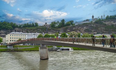 SALZBURG, AUSTRIA - 8 Mayıs 2023: Marko-Feingold-Steg 'in aşk kilitleriyle görüntüsü. Eski adı Makartsteg ve Müze Steg, Salzach Nehri üzerinde yaya ve bisikletçiler için bir köprüdür..