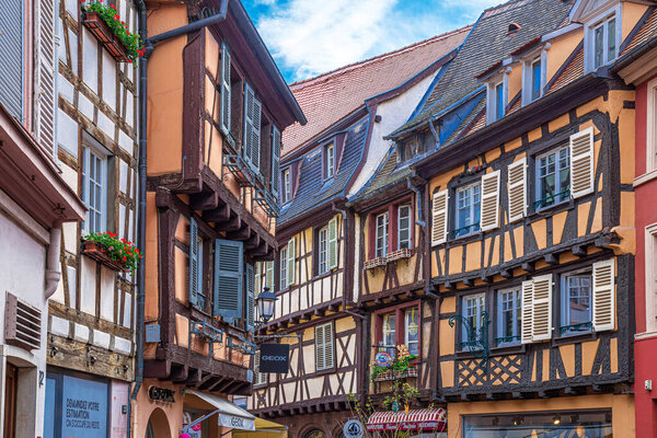 COLMAR, FRANCE - MAY 5, 2023: Traditional Alsatian buildings, with cheerful decorations on the facade, located in a medieval buildings with typical architecture of the area in old town.