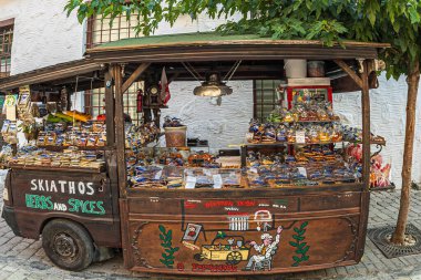 SKIATHOS TOWN, SKIATHOS ISLAND, GREECE - 20 AĞUSTOS 2023: Papadiamanti caddesinde, eski kasabada, bir sürü bitki ve baharat içeren komik bir araba, yerel geleneksel ve renkli lolipoplar satışa sunuldu.