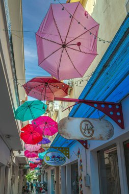 SKIATOS TOWN, SKIATHOS ADA, GREECE - 20 AĞUSTOS 2023: Politechou Caddesi, eski şehrin dar bir caddesi, asılı renkli şemsiyeler, güzel dekore edilmiş sanat dükkanları ve barları.