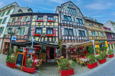 COLMAR, FRANCE - 5 Mayıs 2023: Geleneksel Alsas restoranı, ön cephede neşeli ve romantik dekorasyonlarla, bölgenin tipik mimarisine sahip bir ortaçağ evinde yer alıyor..