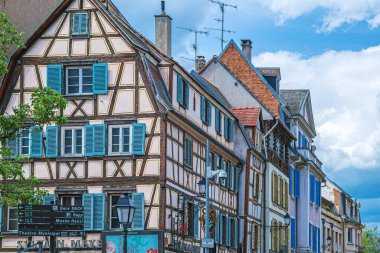 COLMAR, FRANCE - 5 Mayıs 2023: Geleneksel Alsas binaları, ön cephede neşeli süslemeler ile, eski kasabanın tipik mimarisine sahip bir ortaçağ binası.