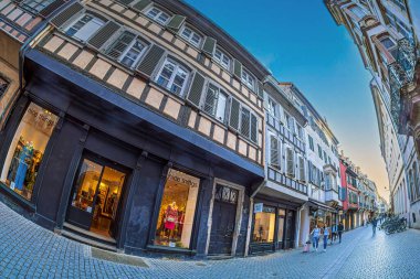 STRASBOURG, ALSACE, FRANCE - 4 Mayıs 2023: Rue des Juifs, eski kasaba ve tarihi merkezde bir alışveriş caddesi, tipik ortaçağ Alsas mimarisi ve evlerin zemin katındaki dükkanlar.