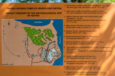 Romanya 'nın tarihi Histria kalesinin kalıntılarına sahip bilgi paneli. MÖ 657 yılında MÖ 7. yüzyılda Karadeniz 'de bir liman olarak kurulan ve M.S. 7. yüzyılda Avar-Slav tarafından yok edilen Yunan yerleşimciler tarafından kuruldu..