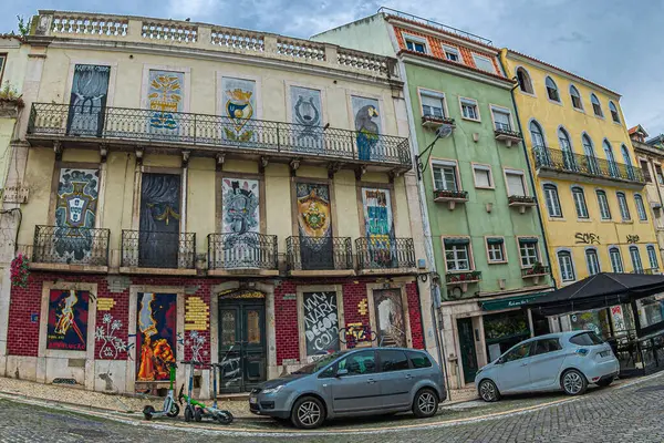 LISBON, PORTUGAL - 6 Nisan 2024: Placa da Alegria 'daki evlerin cephelerinde grafiti ve sokak resimleri bulunan komik sokak dekorasyonları.