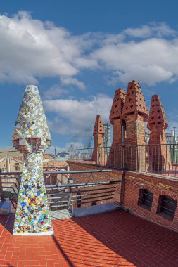 BARCELONA, SPAIN - 14 Nisan 2024: Mimar Antoni Gaudi tarafından tasarlanan Palau Guell 'in çatısında farklı renklerde seramiklerle kaplı orijinal bacalar. İnşaat 1886-1888, UNESCO.