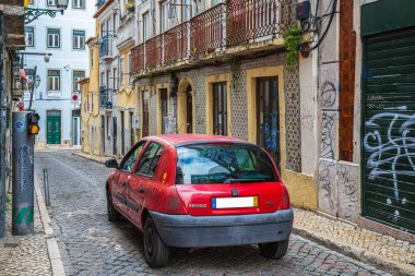LISBON, PORTUGAL - 7 Nisan 2024: Lizbon 'daki komik ve tipik trafik durumu. Küçük bir araba küçük bir caddede küçük bir trafik lambasında durur..