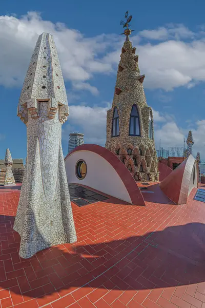 stock image BARCELONA, SPAIN - APRIL 14, 2024: Original chimneys covered with ceramics of different colors on the roof of the Palau Guell designed by architect Antoni Gaudi. Built 1886-1888, UNESCO.