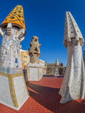 BARCELONA, SPAIN - 14 Nisan 2024: Mimar Antoni Gaudi tarafından tasarlanan Palau Guell 'in çatısında farklı renklerde seramiklerle kaplı orijinal bacalar. İnşaat 1886-1888, UNESCO.